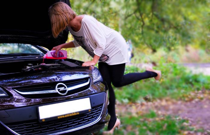 девушка заливает антифриз в машину